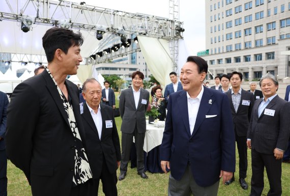 [서울=뉴시스] 윤석열 대통령이 12일 서울 용산 대통령실 잔디광장에서 칸 영화제 수상기념 영화 관계자 초청 리셉션 및 만찬에 앞서 배우 정우성과 대화하고 있다. (사진=대통령실 제공) 2022.06.12. photo@newsis.com