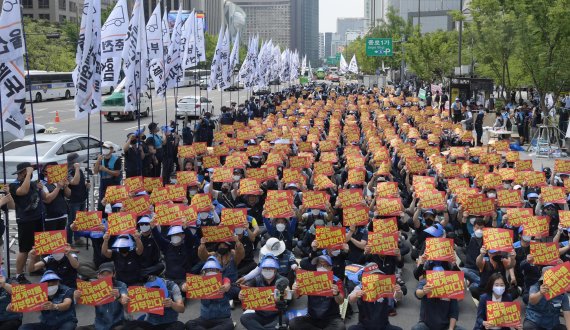 민주노총 서비스연맹 전국택배노동조합원들이 13일 서울 세종대로에서 열린 '임금삭감, 쉬운 해고 노예계약 저지' 우체국 택배 노동자 총력 결의대회에서 노예계약서를 거부하는 손 피켓을 들고 있다.