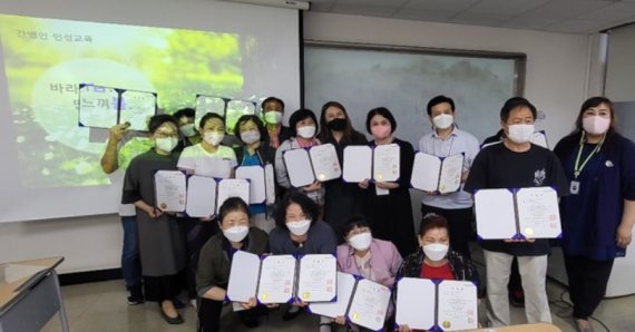 동국대 미래융합연구원에서 교육 프로그램을 이수한 간병보호사들이 수료증을 들어보이고 있다.