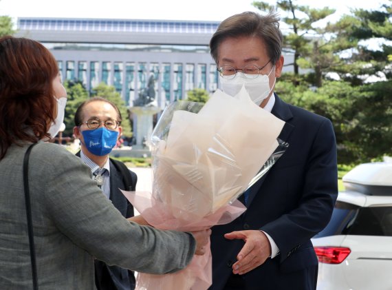 이재명 더불어민주당 의원이 7일 오전 서울 여의도 국회의원회관에 도착해 지지자로부터 꽃다발을 받고 있다. (공동취재) 2022.6.7/뉴스1 © News1 이재명 기자