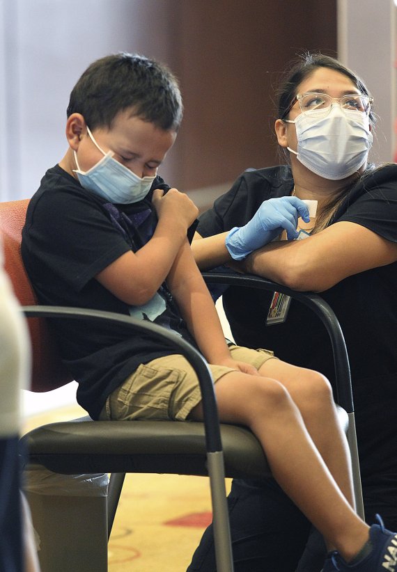 [에딘버그=AP/뉴시스] 3일(현지시간) 미 텍사스주 에딘버그의 에딘버그 컨퍼런스 센터에서 한 8세 어린이가 화이자 백신을 접종하면서 고개를 돌리고 있다. 미국 질병통제예방센터(CDC)가 전날 5∼11세 어린이를 대상으로 화이자-바이오엔테크의 코로나19 백신 접종을 승인하면서 이 연령대의 어린이들이 백신 접종을 시작했다. 2021.11.04.