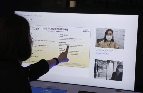 최근 서울 신한은행 강남중앙지점 디지털라운지에서 시민이 '디지털데스크'를 통해 본점 담당 상담 직원과 금융 업무를 보고 있다. 뉴시스