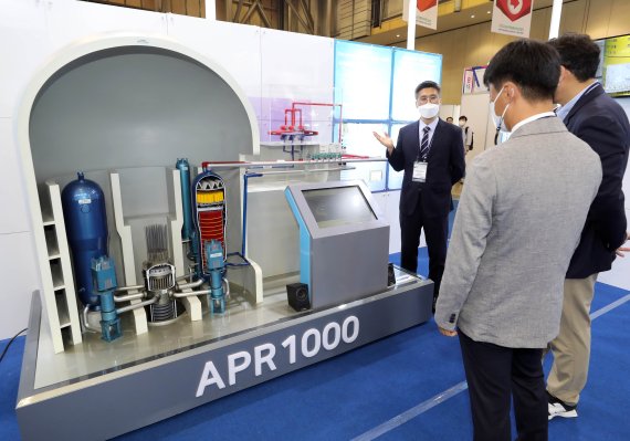 [부산=뉴시스] 하경민 기자 = '2022 부산국제원자력산업전'이 개막한 27일 부산 해운대구 벡스코 제1전시장 내 한국수력원자력 부스를 찾은 관람객들이 유럽요건 적용 수출용 중형원전 모형을 구경하고 있다. 29일까지 열리는 이번 행사에는 관련 기업 110곳이 참가해 원자력 산업 관련 전반에 걸쳐 새로운 기술과 제품을 선보인다. 2022.04.27. yulnetphoto@newsis.com