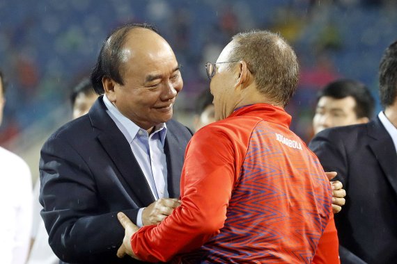 [하노이=AP/뉴시스] 베트남 축구 대표팀 박항서(오른쪽) 감독이 22일(현지시간) 베트남 하노이의 미딘 국립경기장에서 열린 제31회 동남아시안(SEA) 경기 남자 축구 태국과의 결승전을 승리로 이끈 후 응우옌 쑤언 푹 베트남 주석의 축하를 받고 있다. 베트남은 인도네시아를 꺾고 결승에 올라온 태국을 1-0으로 물리치고 이 대회 2연속 금메달을 따냈다. 2022.05.23.