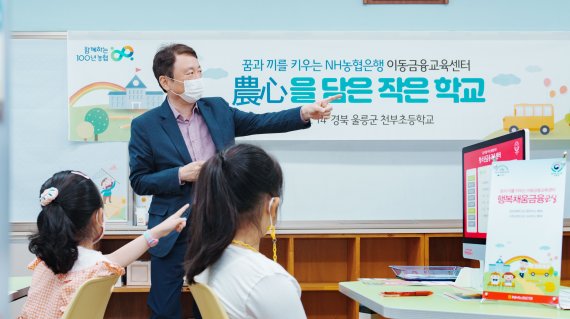 지난 14일 울릉군 북면 천부초등학교를 방문한 NH농협은행 권준학 은행장이 '행복채움금융교실' 은행원 체험을 함께하고 있다. NH농협은행 제공