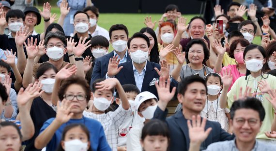 [서울=뉴시스] 전신 기자 = 윤석열 대통령이 19일 서울 용산 대통령실 청사 앞 잔디마당에서 열린 대통령실 이전 기념 어린이·주민 초대 행사에서 주민들과 함께 환영의 의미를 담아 손을 흔들고 있다. 2022.06.19. photo1006@newsis.com