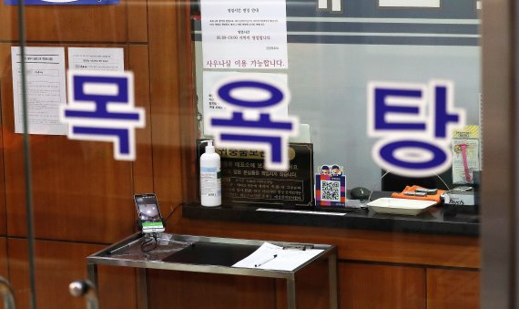 2021년 3월 16일 서울의 한 목욕탕에 전자출입명부와 수기로 작성하는 출입명부가 놓여 있다. 2021.3.16/뉴스1 © News1 박지혜 기자