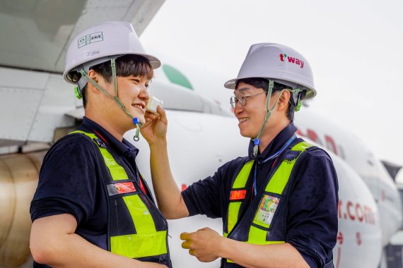 티웨이항공 정비사들이 김포공항 주기장에서 새로 지급된 선스틱 제품을 바르고 항공기 정비 및 점검 업무를 수행하고 있다. 티웨이항공 제공