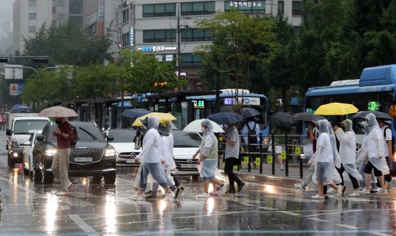 장맛비가 내리는 23일 오후 서울 세종대로사거리 횡단보도에서 우산을 쓰고 우비를 입은 시민들이 발걸음을 재촉하고 있다. 2022.6.23/뉴스1 © News1 박세연 기자