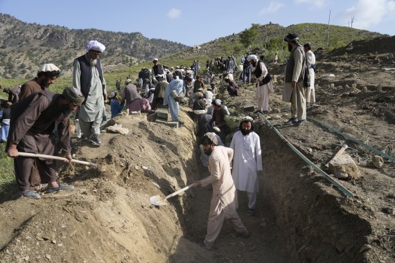 [가얀=AP/뉴시스] 23일(현지시간) 아프가니스탄 팍티카주 가얀 마을에서 주민들이 지진으로 숨진 희생자들의 시신을 매장하기 위해 공동묘지를 만들고 있다. 2022.06.24.
