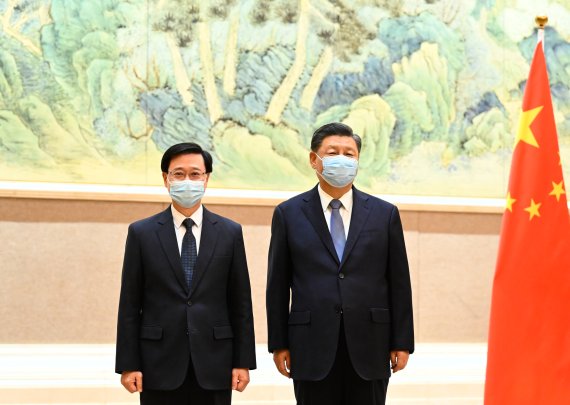 [베이징=신화/뉴시스] 시진핑(오른쪽) 중국 국가주석이 30일 베이징에서 존 리 홍콩 행정장관 당선인을 만나 기념 촬영을 하고 있다. 시 주석은 "새 행정부가 새로운 분위기를 조성해 홍콩 발전의 새로운 장을 열 것"이라며 "리 당선인이 국가 안보와 홍콩의 번영, 안정을 지키는 데 이바지하길 바란다"라고 말했다. 2022.05.31.