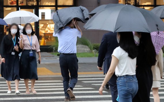 서울을 비롯한 전국에서 장마가 본격적으로 시작된 23일 서울 종로구에서 장대비가 쏟아지자 우산을 챙기지 못한 시민이 외투로 비를 피하고 있다 2022.6.23/뉴스1 © News1 장수영 기자