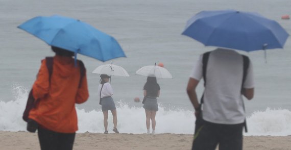 부산 해운대해수욕장을 찾은 관광객들이 우산을 쓰고 바다를 바라보고 있다. 2018.6.28/뉴스1 © News1