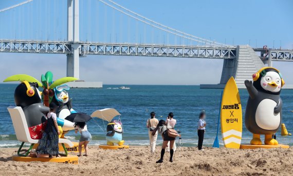 [부산=뉴시스] 하경민 기자 = 부산 7개 해수욕장 전면 개장을 하루 앞둔 30일 수영구 광안리해수욕장에 EBS 인기 크리에이터 펭수 모형이 설치돼 시민과 관광객들의 눈길을 사로잡고 있다. 7월 1일부터 9월 30일까지 전시되는 펭수 모형은 높이 4m 자이언트 펭수를 비롯해 SUP(서서 타는 패들보드) 펭수와 선탠 펭수, 마스크 낙하산 펭수 등 총 7개가 설치됐다. 2022.06.30. yulnetphoto@newsis.com