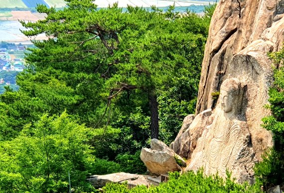 마애석가여래좌상. 높이 6m. 돌 속의 부처가 밖으로 드러난 듯 조각된 모습이다 © 뉴스1