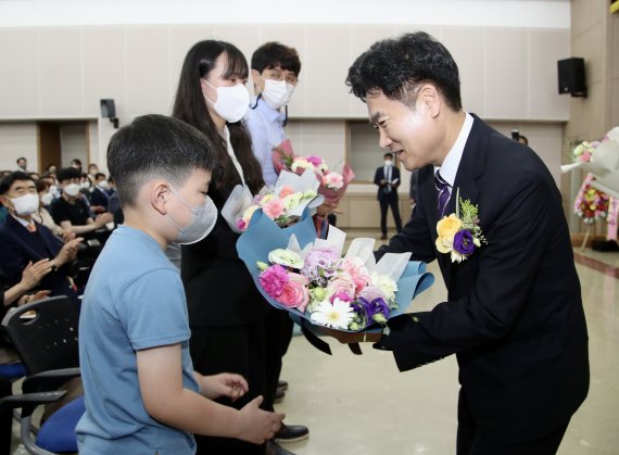 김대중 전남도교육감이 1일 열린 취임식에서 전남도민과 교육가족 모두와 함께하고 같이 나아가야 한다는 의미로 현장에서 최선을 다하고 있는 교육가족 대표 4명(이준수 장애인교원노동조합 전남지부장, 7월 1일 신규임용된 금성초교 양혜선 주무관, 목포삼학초 2학년 이찬서 학생, 백제고 1학년 학부모 신영희씨)에게 꽃다발을 전달해 눈길을 끌었다. 사진은 김대중 교육감이 이찬서 학생에게 꽃다발을 건네고 있는 모습.사진=전남도교육청 제공