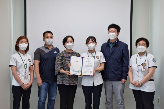 갑을녹산병원 주순남 간호부장(오른쪽)이 박영란 부산시 강서구 보건소 재택치료팀장으로부터 부산시장 표창장을 전달받고 기념촬영을 하고 있다. 갑을의료재단 제공