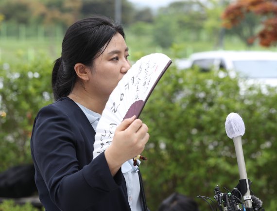 김성진 아이카이스트 대표의 법률 대리인인 김소연 변호사가 5일 오후 경기 의왕시 서울구치소 앞에서 취재진을 향해 부채를 들어보이고 있다. 2022.7.5/뉴스1 © News1 신웅수 기자