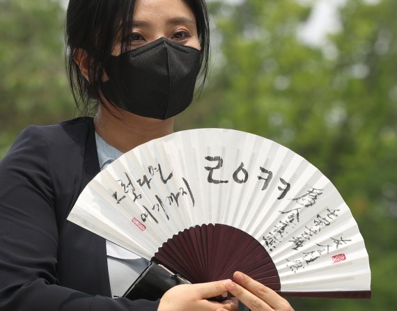 김성진 아이카이스트 대표의 법률 대리인인 김소연 변호사가 5일 오후 경기 의왕시 서울구치소 앞에서 취재진을 향해 부채를 들어보이고 있다. 2022.7.5/뉴스1 © News1 신웅수 기자
