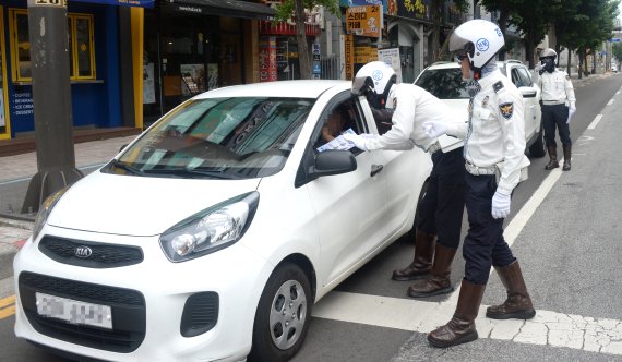전북경찰관들이 지난 6일 전북 전주시 본병원 사거리에서 7월 12일부터 시행할 개정 도로교통법 보행자 보호의무 강화 관련 개도활동을 하며 운전자들에게 안내를 하고 있다. /사진=뉴시스