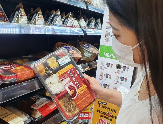 이마트24 매장에서 모델이 일품쌀로 변경된 도시락을 구입하고 있다. 이마트24 제공.