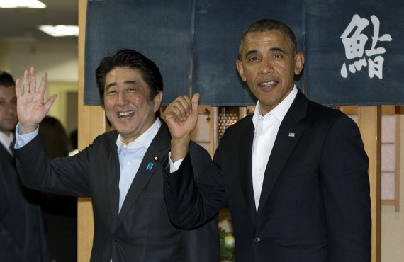 지난 2014년 당시 버락 오바마 미국 대통령이 일본을 방문했을 당시, 일본 도쿄의 한 일식당에서 아베 신조 총리와 취재진을 향해 손을 들고 있다. AP뉴시스