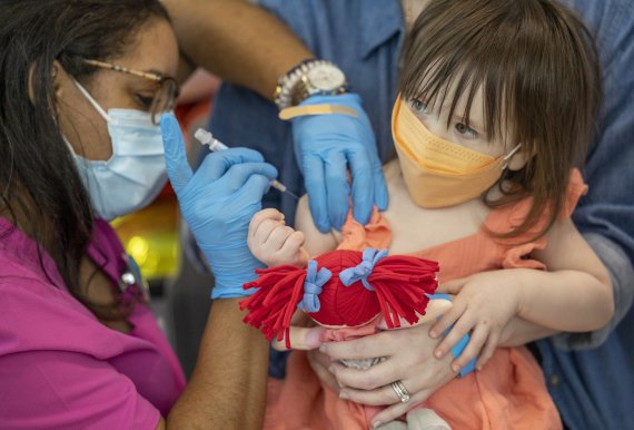 [뉴올리언스=AP/뉴시스] 21일(현지시간) 미 루이지애나주 뉴올리언스 아동병원에서 1세 여아가 인형을 쥔 채 코로나19 백신 접종을 하고 있다. 미국은 이날부터 생후 6개월 이상 5세 미만 영유아에 대한 백신 접종을 시작했다. 2022.06.22.