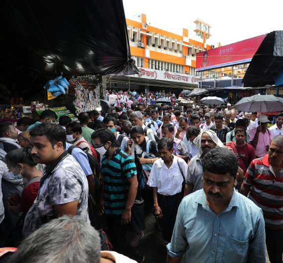 epa10064781 Indian commuters walk through a market near a rail station in Kolkata, India, 11 July 2022. India is predicted to replace China as the most populous country in the world by 2025, according to data and estimates by the United Nations (UN). The United Nations Population Fund (UNFPA) celebr