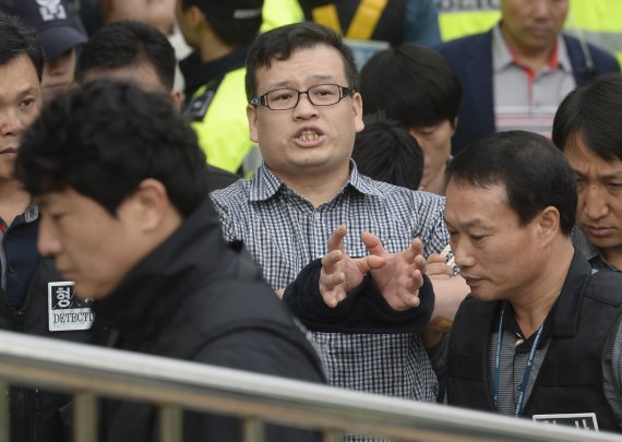 [서울=뉴시스]최진석 기자 = 오패산터널 사제총 총격사건 피의자 성병대(가운데)가 지난 2016년 10월26일 오전 서울 강북구 오패산터널 인근 도로에서 현장검증하며 소리를 지르고 있다. 2016.10.26. myjs@newsis.com