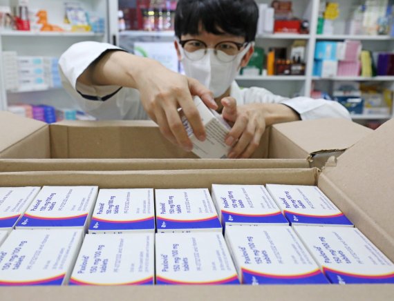 서울의 한 약국에서 약사가 코로나 치료제 팍스로비드를 꺼내고 있다. 뉴스1 제공