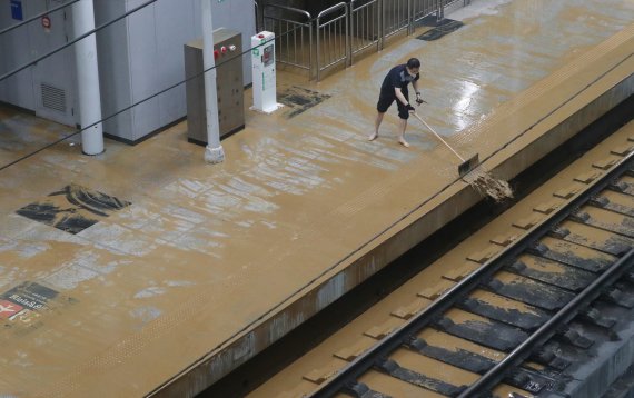 수도권 지역에 호우주의보가 내려진 13일 오후 경기 광명시 일직동 경부선(KTX) 광명역에 인근 신안산선 공사현장의 토사와 흙탕물이 지하 승강장으로 유입돼 현장 관계자들이 토사를 치우고 있다. 2022.7.13/뉴스1 © News1 김영운 기자