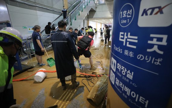 수도권 지역에 호우주의보가 내려진 13일 오후 경기 광명시 일직동 경부선(KTX) 광명역에 인근 신안산선 공사현장의 토사와 흙탕물이 지하 승강장으로 유입돼 현장 관계자들이 토사를 치우고 있다. 2022.7.13/뉴스1 © News1 김영운 기자