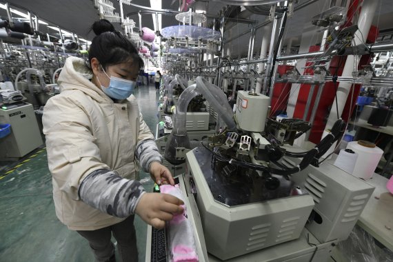 지난 3월1일 중국 안후이성 중부 푸맘현의 한 공장에서 여성 노동자 1명이 양말 뜨개질 기계를 작동시키고 있다. AP뉴시스