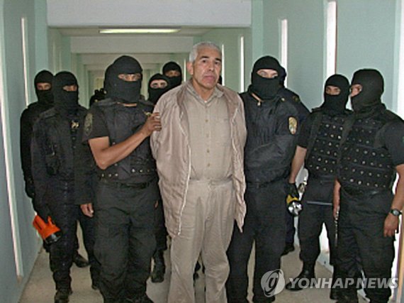 2005년 수감 당시 카로 킨테로 (FILES) In this file handout picture released by the Mexican Federal Preventive Police (PFP) on January 29, 2005, members of the PFP escort drug trafficker Rafael Caro Quintero, at the Puente Grande prion in Guadalajara, Jalisco State, Mexico. - Mexico has captured Rafael Caro Qui