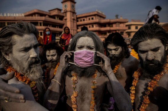 인도의 팬데믹을 처참하게 표현한 사진으로 퓰리처상을 수상한 로이터의 사진. 하리드와르 쿰브 멜라 축제에서 힌두교의 성자 '나가 사두'가 갠지스강에 들어가기 전 얼굴에 마스크를 씌우는 장면이다. 뉴스1