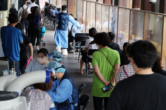7만3천582명의 코로나19 신규 확진자가 발생, 83일 만에 최다를 기록한 19일 서울 송파구 보건소 선별진료소에서 시민들이 검사를 기다리고 있다.