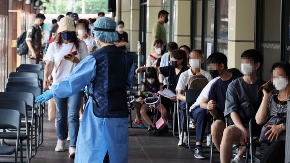 7만3천582명의 코로나19 신규 확진자가 발생, 83일 만에 최다를 기록한 19일 서울 송파구 보건소 선별진료소에서 시민들이 검사를 기다리고 있다.