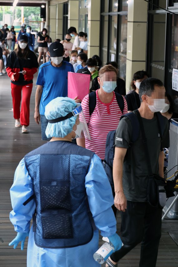 7만3천582명의 코로나19 신규 확진자가 발생, 83일 만에 최다를 기록한 19일 서울 송파구 보건소 선별진료소에서 시민들이 검사를 기다리고 있다.