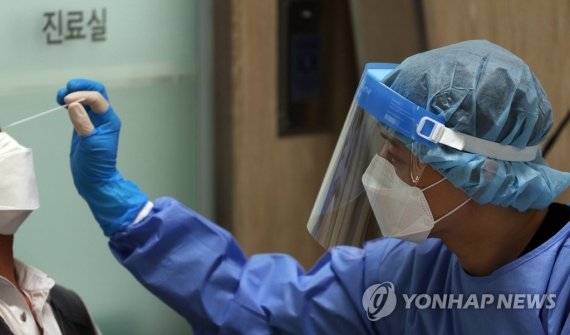 20일 서울 마포구보건소 선별진료소에서 한 의료진이 검사하고 있다. 연합뉴스 제공