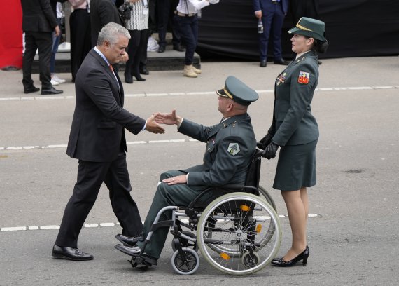 [보고타=AP/뉴시스] 이반 두케(왼쪽) 콜롬비아 대통령이 20일(현지시간) 보고타에서 제212주년 독립기념일을 맞아 열린 퍼레이드에 참석한 한 상이군인과 악수하고 있다. 2022.07.21.