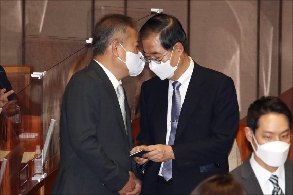 한덕수 국무총리(오른쪽)와 이상민 행정안전부 장관이 지난달 21일 서울 여의도 국회에서 열린 제398회 국회(임시회) 제3차 본회의에 출석해 쪽지를 보며 대화를 나누고 있다.사진=박범준 기자