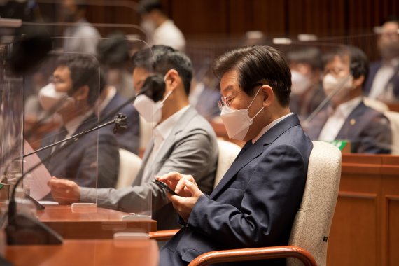 더불어민주당 이재명 의원이 22일 국회 본청 예결위회의장에서 열린 의원총회에 참석, 휴대전화를 보고 있다. [국회사진기자단]