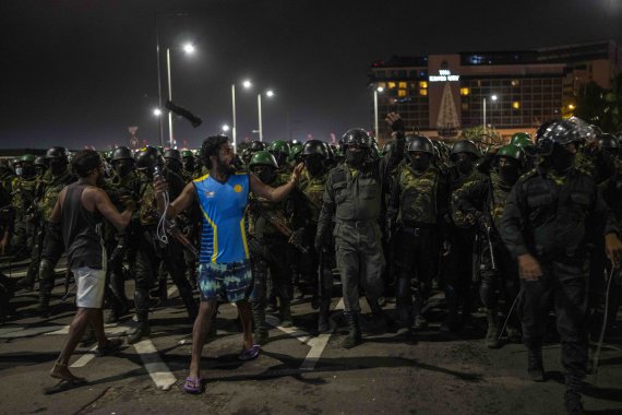[콜롬보=AP/뉴시스] 22일(현지시간) 스리랑카 콜롬보 대통령비서실 외곽 시위캠프 현장에서 한 시위 참가자가 경찰을 향해 구호를 외치고 있다. 스리랑카 경찰은 이날 밤 반정부 시위대 캠프를 급습해 텐트를 철거했다. 2022.07.22.