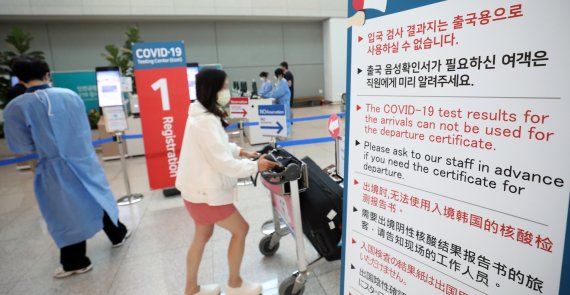 21일 인천국제공항 제2여객터미널 동편에 설치된 코로나19 입국자 전용 검사센터에서 의료진이 해외입국자의 PCR검사 절차를 돕고 있다. 뉴스1