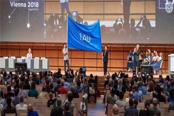 지난 2018년 오스트리아 빈에서 개최된 제30차 IAU 총회에서 대회기를 넘겨받는 강혜성 교수(조직위원장)와 박명구 교수(한국천문학회장) 부산시 제공
