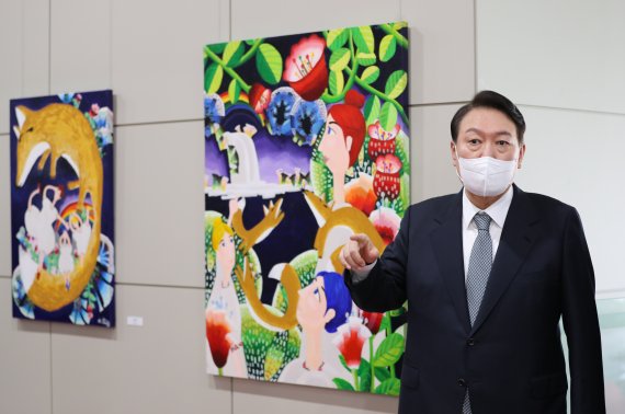 윤석열 대통령이 25일 오전 용산 대통령실에서 출근길 약식 기자회견(도어스테핑)을 마친 뒤 로비에 걸린 그림을 둘러보고 있다. 이날 대통령실 1층 양옆 벽면에는 발달장애 작가들의 작품 15점이 처음 전시됐다. 대통령실사진기자단 2022.7.25/뉴스1 © News1 안은나 기자