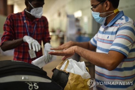 지난달 16일(현지시간) 인도 첸나이의 국제공항에서 보건직원들이 입국 승객들의 원숭이두창 증상 여부를 살펴보고 있다.EPA연합뉴스