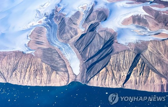 빙하가 녹아 맨땅 드러낸 그린란드 An aerial view of icebergs and ice sheet near Pituffik, Greenland on July 19, 2022 as captured on a NASA Gulfstream V plane while on an airborne mission to measure melting Arctic sea ice. - New observations from ICESAT-2 show remarkable Arctic Sea ice thinning in just three years.