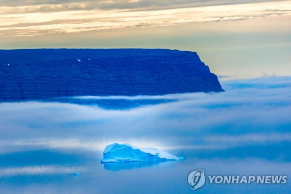 바다로 녹아드는 빙하 Icebergs seen through the fog float in the Baffin Bay near Pituffik, Greenland on July 20, 2022 as captured on a NASA Gulfstream V plane while on an airborne mission to measure melting Arctic sea ice. - New observations from ICESAT-2 show remarkable Arctic Sea ice thinning in just three 