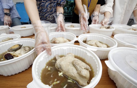 [광주=뉴시스] 중복인 26일 광주 북구 풍향동 행정복지센터에서 열린 '영양가득 사랑가득' 어르신 건강기원 복달임 행사에서 동 직원들이 관내 취약계층 세대에 삼계탕을 배달하고 있다. 풍향동은 복달임 행사를 5년째 이어오고 있다. (사진=광주 북구 제공) 2022.07.26. photo@newsis.com *재판매 및 DB 금지